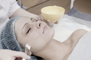 Kvinna som får en kemisk peeling i ansiktet.
