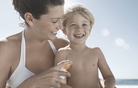 Mamma som applicerar solskydd