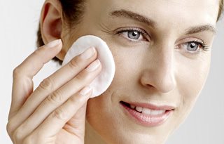 Kvinna som använder ansiktsvatten