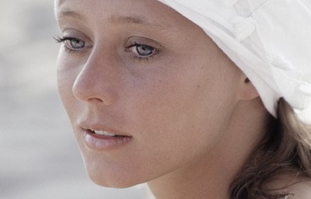 Kvinna med vit huvudbonad.