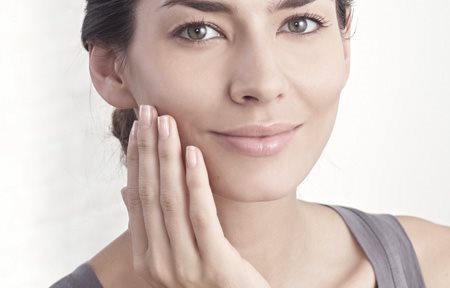 Kvinna som applicerar kräm i ansiktet