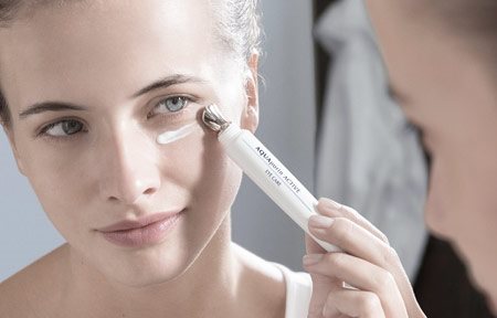 Kvinna som applicerar ögonprodukt.