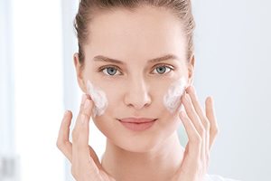 Kvinna smörjer in sitt ansikte